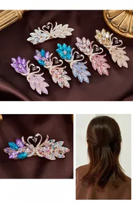 Detailed swan hair clip with colorful crystals on a textured silk background