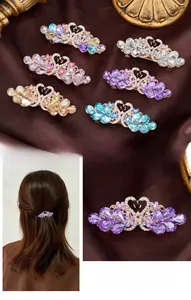 Detailed set of six crystal swan hair clips in various colors on brown satin background