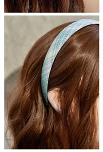 Detailansicht des blau-weiß karierten Stoff-Haarreifens auf braunem Haar