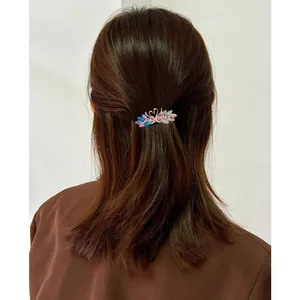 Elegant swan crystal hair clip with gradient rhinestones on woman's brown hair