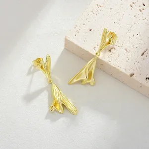 Dettaglio macro di orecchini irregolari placcati oro 14K su pietra decorativa
