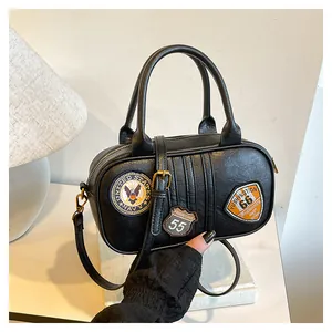 Macro detail of retro black PU leather bag with embroidered patches and vintage hardware