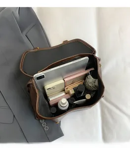 Internal view of large brown retro leather bag showing storage for laptop and essentials