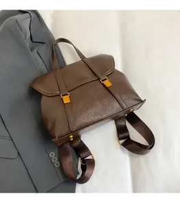 Macro shot of dark brown retro leather backpack with golden buckles and shoulder straps