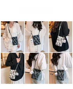 Close-up of stylish cow print crossbody phone bag with cute plush charm and woven strap