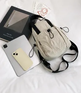 Beige nylon backpack size comparison with iPad and phone showing spacious interior
