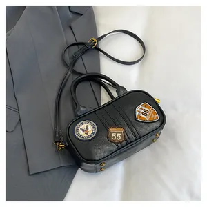 Detail of black Boston bag featuring American navy embroidery and gold hardware accents
