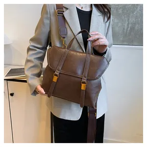 Detailed view of dark brown vintage leather bag with adjustable strap and metallic hardware