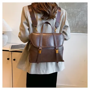 Detail of vintage dark brown leather backpack with gold buckles in a lifestyle setting