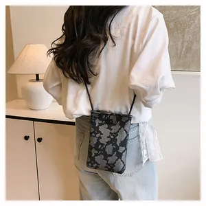 Lifestyle shot of a rectangle crossbody phone bag with black cow print pattern