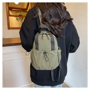Olive green pleated nylon backpack detail showing durable fabric and adjustable shoulder strap