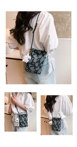 Close-up of small black marble patterned crossbody phone bag with fluffy charm detail