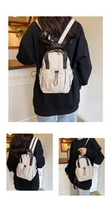 Detail view of beige nylon backpack showing drawstring texture and black contrast straps