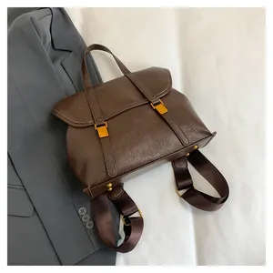 Detail view of the brown leather backpack rear with adjustable wide fabric straps