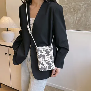 Fashionable cow print small crossbody bag with knot strap and metallic logo detail