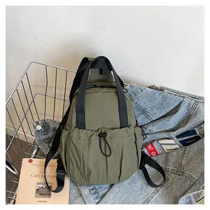 Detail of olive green nylon sling bag with drawstring pocket in a creative lifestyle setting