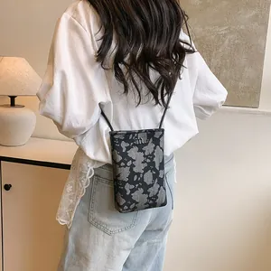 Fashionable crossbody cell phone bag with textured gray pattern and metallic M logo