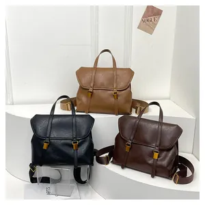 Detail view of vintage PU leather backpacks in black, camel, and dark brown on display