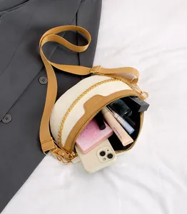 Détail du sac bandoulière crème embossé crocodile avec garniture brune et chaîne dorée