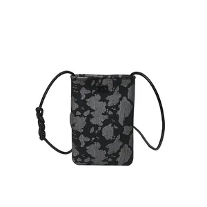 Vertical mini crossbody phone bag with grey spotted pattern and leather strap detail