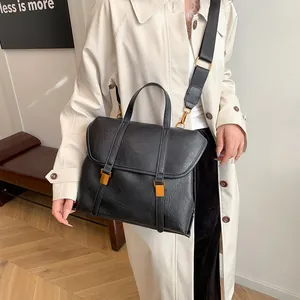 Retro black leather handbag for women featuring a minimalist design and adjustable strap