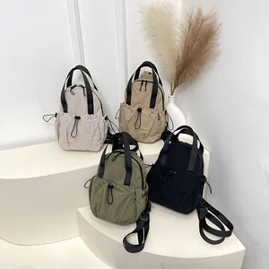 Minimalist nylon pleated backpacks in four colors displayed on a modern display stand