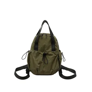 Olive green crinkled nylon backpack with drawstring pockets and adjustable straps