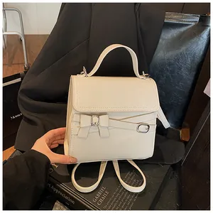 Detailopname van de crèmewitte PU-lederen textuur en zilveren gesp op de mini-handtas