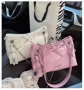 Détail de sacs à bandoulière avec nœuds, chaînes argentées et logo dans une voiture