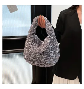 Detailed view of silver ruffled satin handbag with elegant pleats and metallic sheen