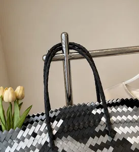 Macro detail of tricolor woven shopping basket with reinforced black handle texture