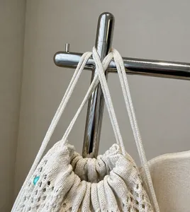Détail des bretelles tissées crème et texture d'un sac cabas en tricot minimaliste