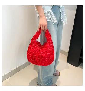 Detail of red pleated handbag with lace ruffles and floral satin texture for women