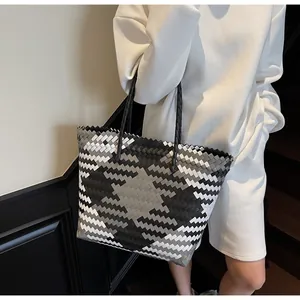 Détail du sac cabas tissé avec des motifs géométriques en losange noir, blanc et gris