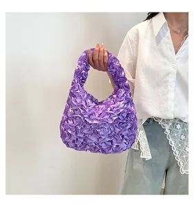 Detailed view of the ruffled purple satin fabric texture on this sweet floral handbag