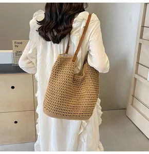 Detail of hand-woven hollow mesh tote bag with durable brown leather shoulder straps