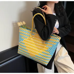Gros plan du sac cabas bicolore tissé en plastique porté avec une tenue de bureau