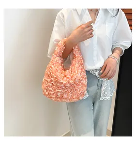 Detail of peach ruffled satin handbag featuring soft lace textures and floral layers