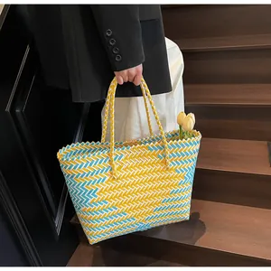 Détail d'un sac cabas tressé en plastique aux motifs jaune et bleu avec tulipes