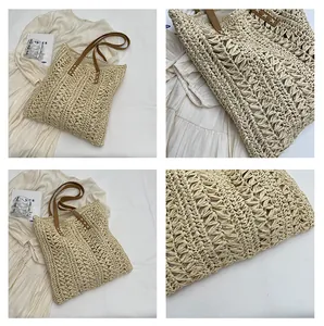Close-up of beige woven beach tote with brown leather straps and white cross-stitching details
