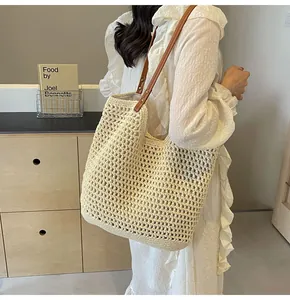 Detail of hand-woven hollow mesh tote bag with durable brown leather shoulder straps