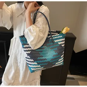 Détail d'un sac cabas tissé à la main avec motifs géométriques colorés et deux poignées