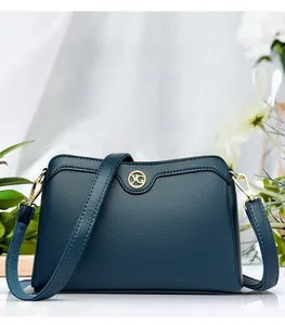 Detail of navy blue pebble leather shoulder bag with golden YG logo and hardware