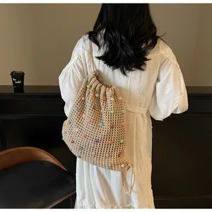 Detail of hand-woven beige tote bag with colorful beads and drawstring closure