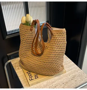 Detail of hand-woven cotton rope tote bag with brown leather handles and spacious interior