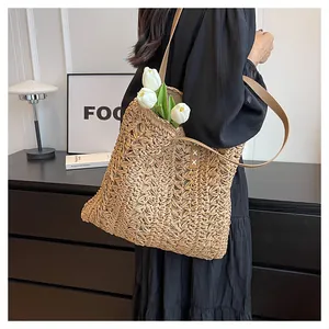 Detailed close-up of handmade woven straw tote with contrast stitching and leather strap