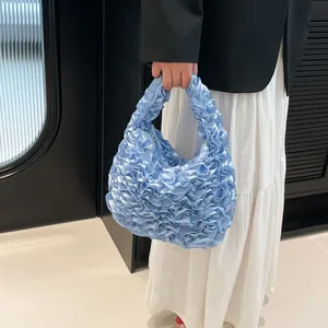 Light blue ruched handbag with satin texture and integrated handle for elegant women