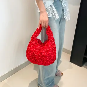 Vibrant red pleated cloud handbag with silk texture shown on a female model with lace outfit
