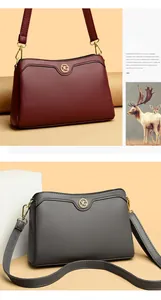 Close-up of burgundy and grey leather shoulder bags with litchi texture and gold YG logo