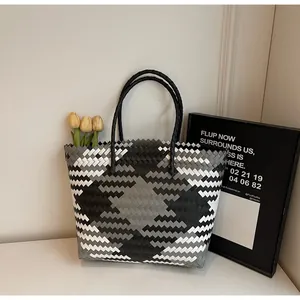 Détail macro du sac cabas tissé géométrique avec motif de losanges gris et blanc